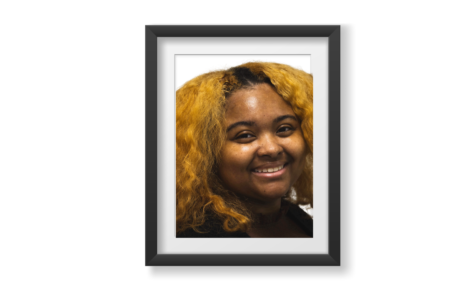 Tamia is an African American female with brown eyes, medium-brown skin, dark brown naturally curly hair with soft features and light freckles across her cheeks.